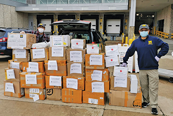 Chuanwu Xi (right) and colleague Bin Zhao help deliver donations of personal protective equipment collected by the association to area health care facilities