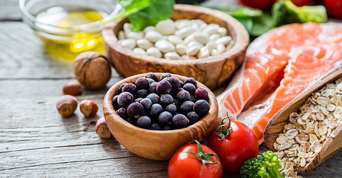 Fruits, vegetables and oils on a counter as they are prepared for a meal