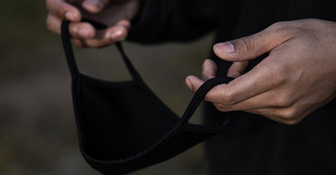 Person holding a black mask.