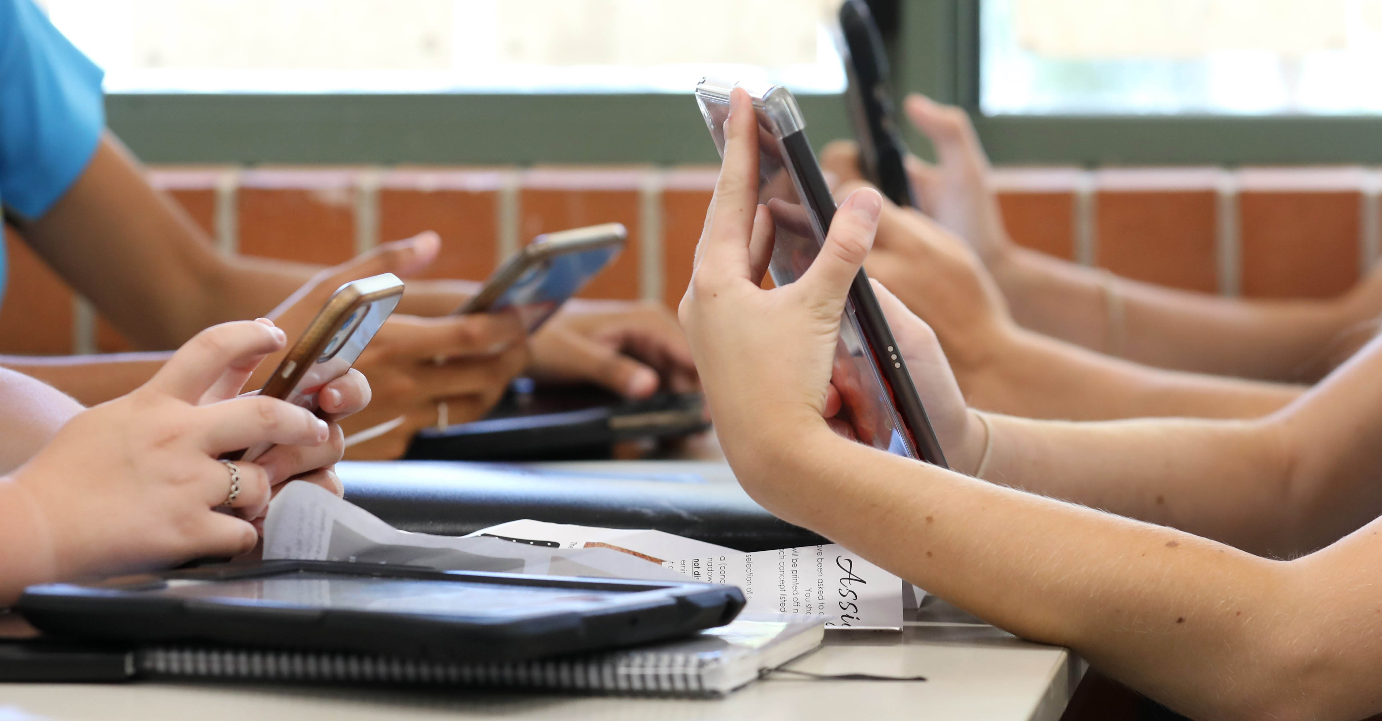 Students hold cellphones.