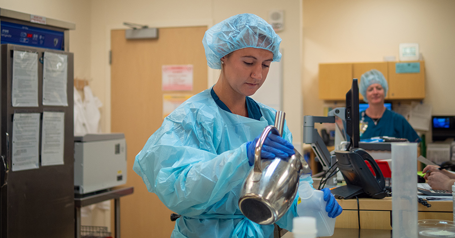 student in lab, mixing substances