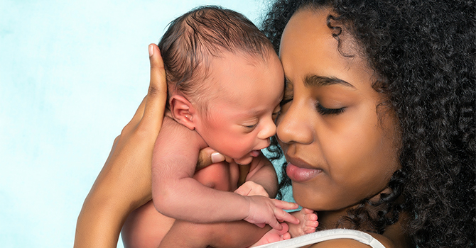 A photo of a Black mother holding her infant child