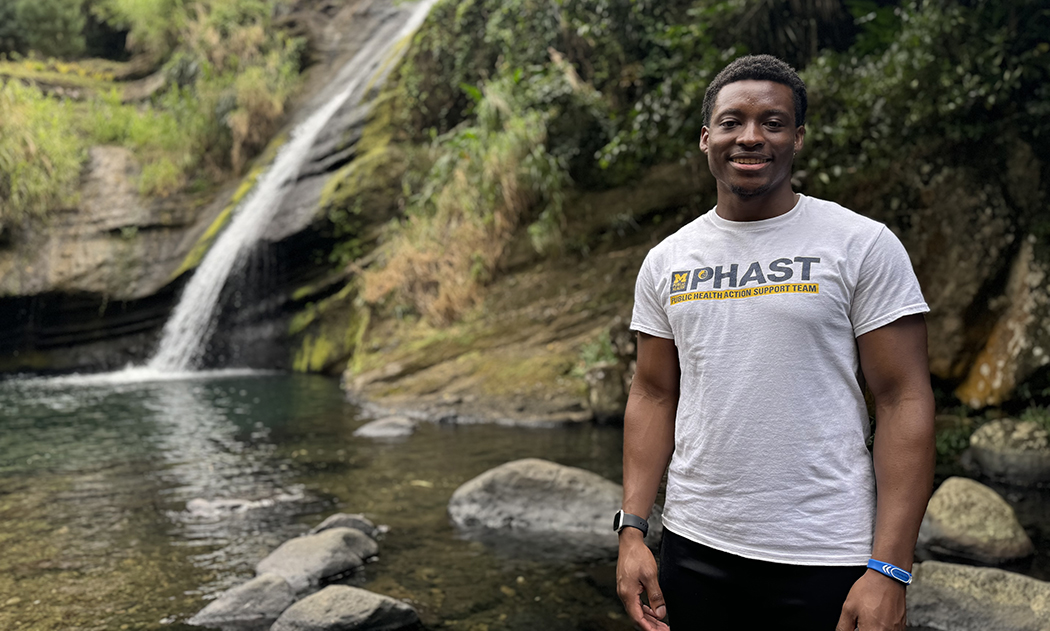 Darius Moore standing in front of a waterfall in Grenada